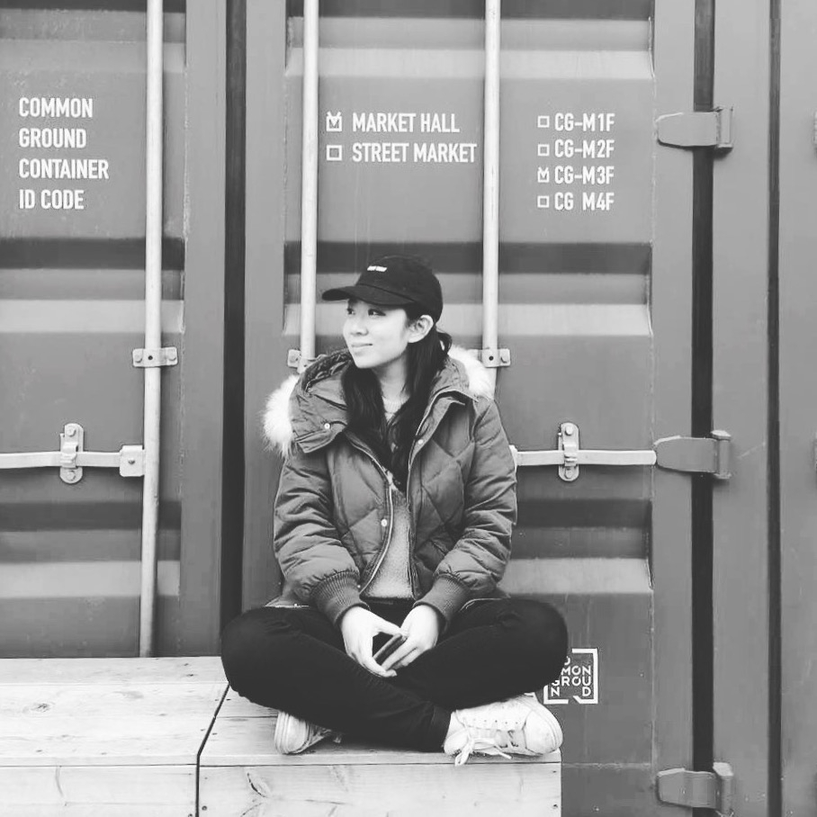 Xinyan Du sits in front of shipping container